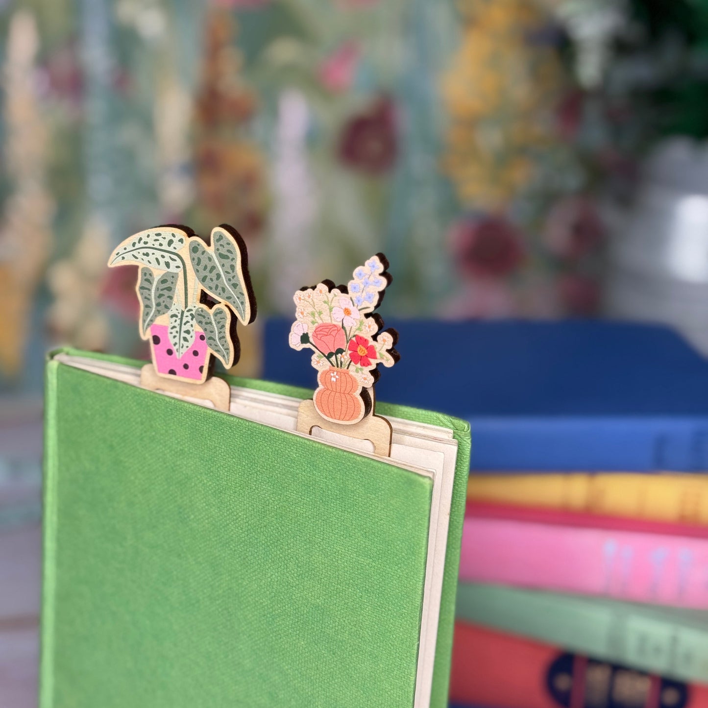 Decorative wooden bookmarks on a green book with a floral background
